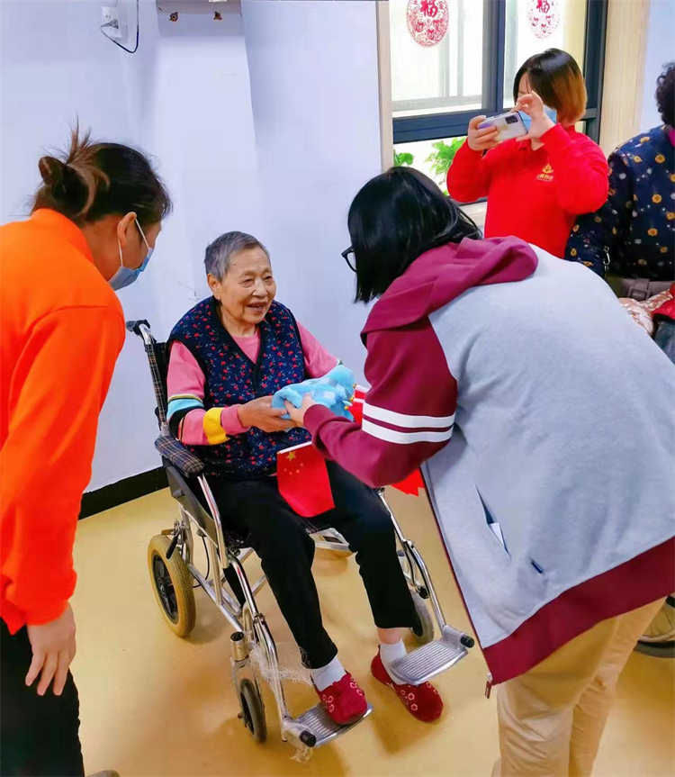 志愿者為老人贈送慰問品.jpg